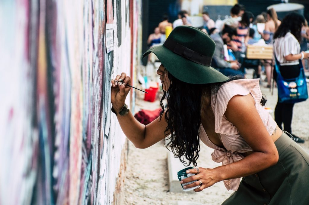 An artiste painting on a wall, portraying creativity